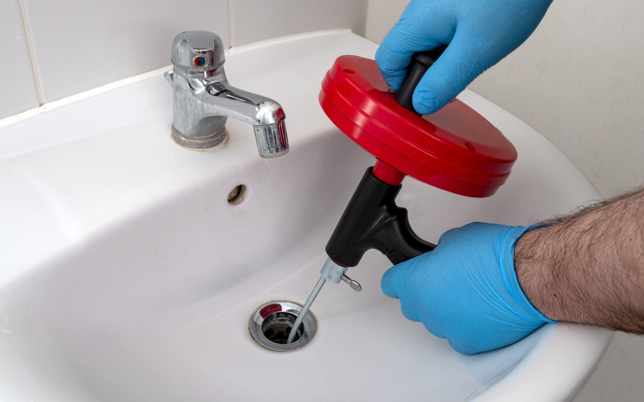 Using a Handheld Auger to Unclog a Sink